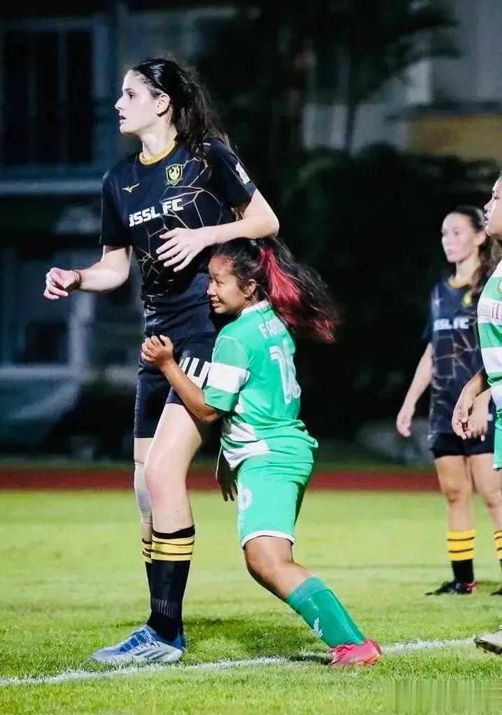 这是新加坡女足联赛中的场景，小巧的后卫在防高大的前锋，可惜差距太大，最终前锋顺利(1)